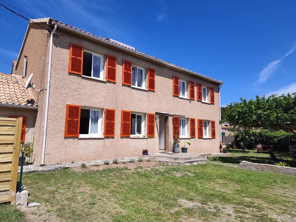a large house with orange shutters on it at le maquis in Sisco