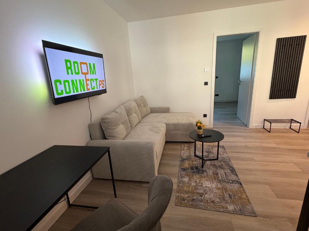 a living room with a couch and a tv on the wall at Idar Apartment 2 in Idar-Oberstein