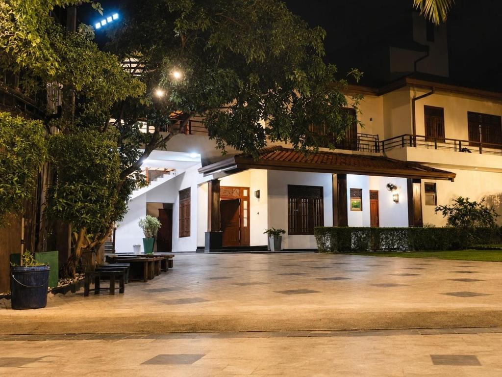a white building with a courtyard at night at Crescent Villa in Kalutara