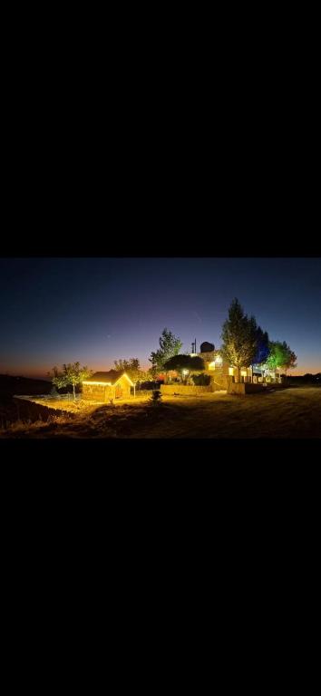 a night time picture of a house with lights at Beit El Jabal in Al Mudayrij