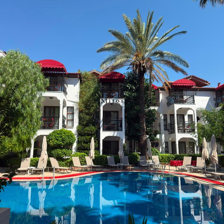 a hotel with a swimming pool in front of a building at Mitos Apartments in Marmaris