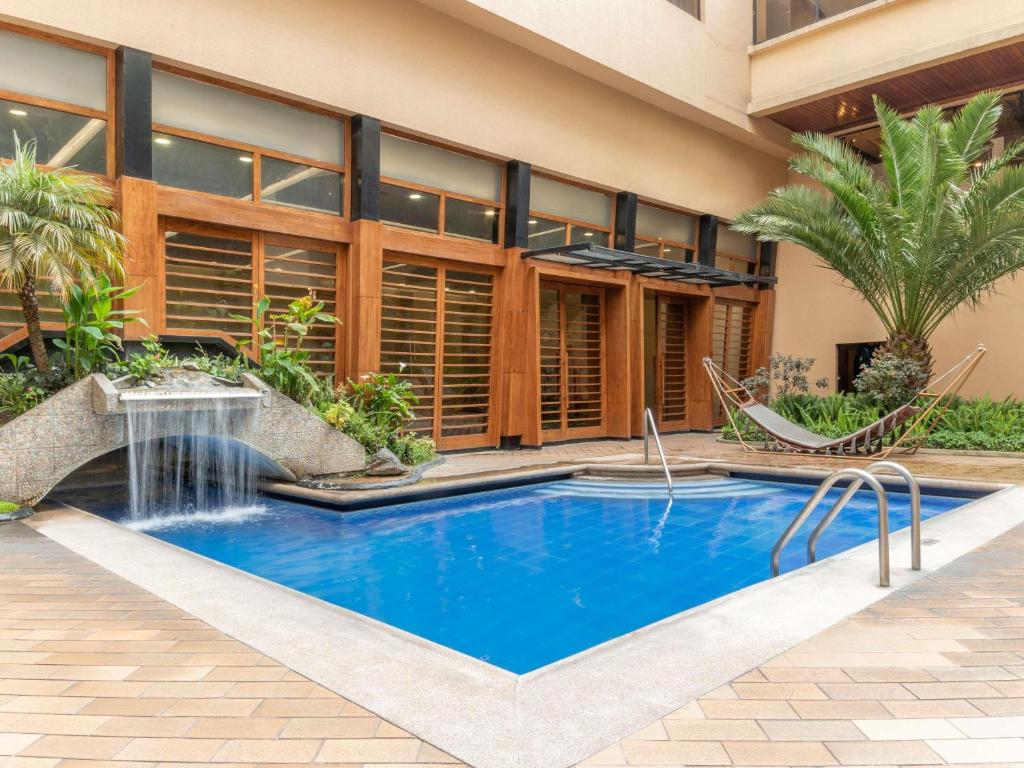 a swimming pool in front of a building at Swissotel Quito in Quito