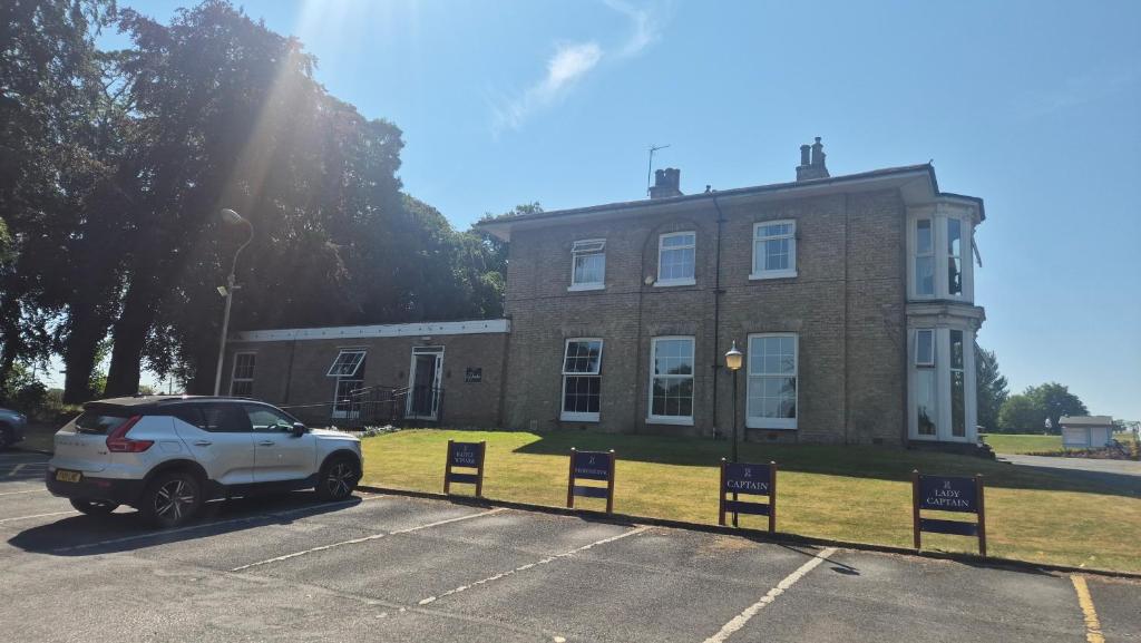 a white car parked in front of a brick building at Crowtree Lodge in Louth