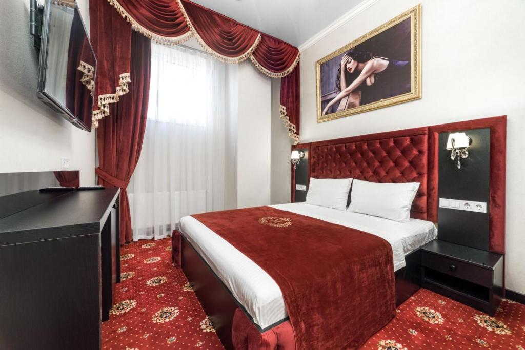 a hotel room with a bed and a television at Arcadia Sea Breeze in Odesa