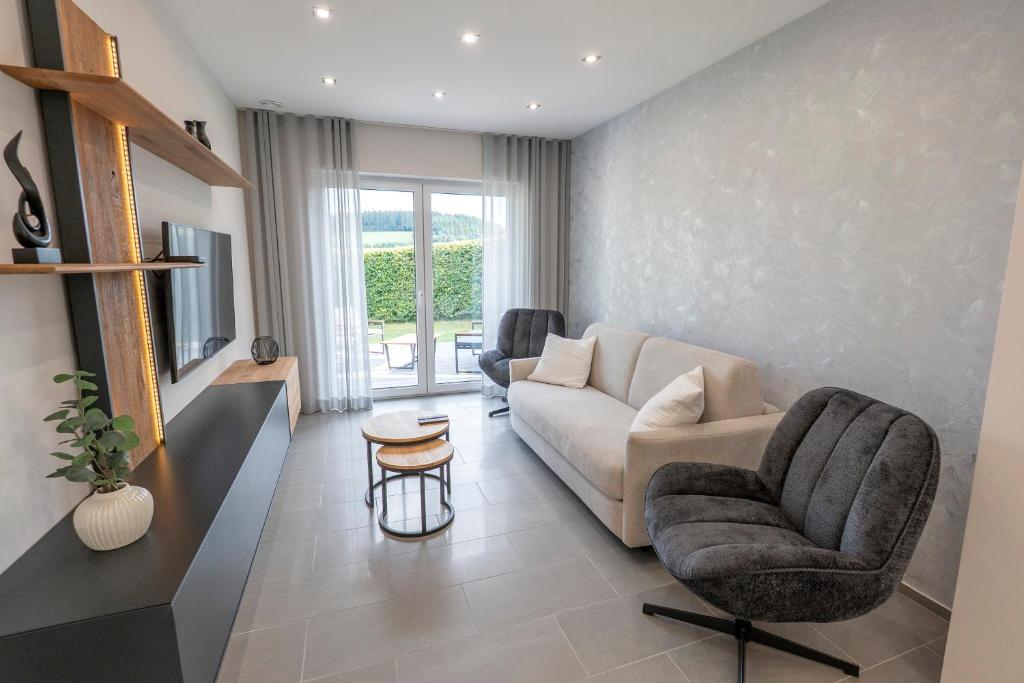 a living room with a couch and a chair at Ferienwohnnung EifelPanorama Berk in Dahlem