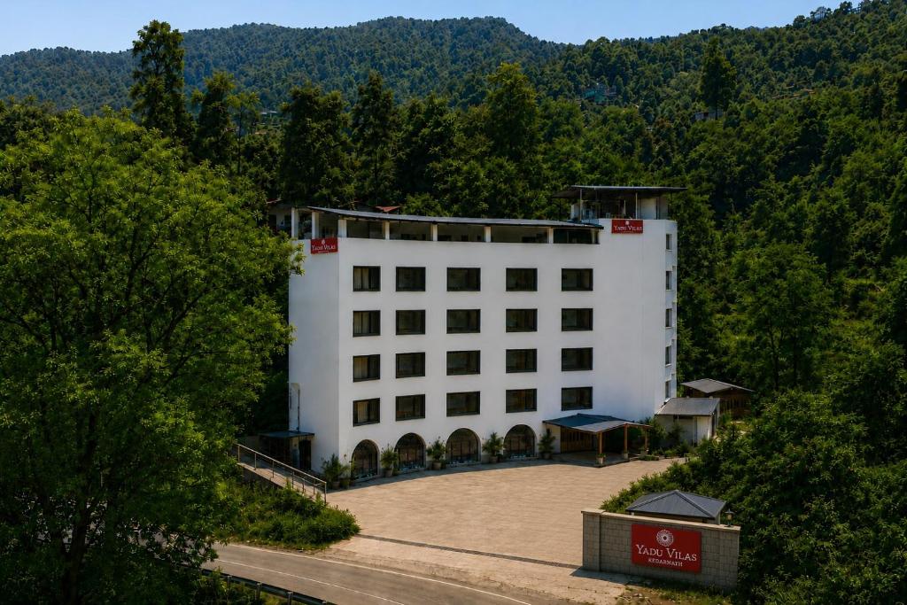 a white building in the middle of a road at Hotel Yadu Vilas in Phata