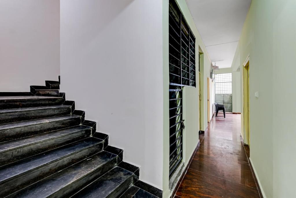 a staircase in a house with a black brick wall at SPOT ON Ganesh in Kaglipur