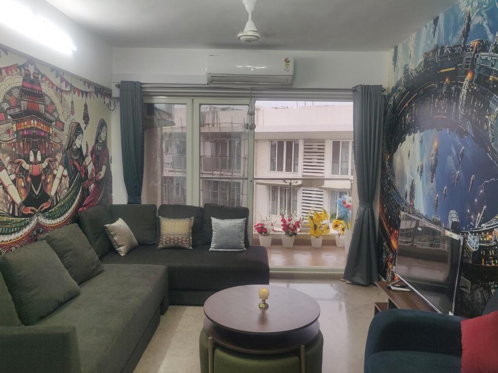 a living room with a couch and a large window at 2BHK Luxurious Apt near BKC in Mumbai