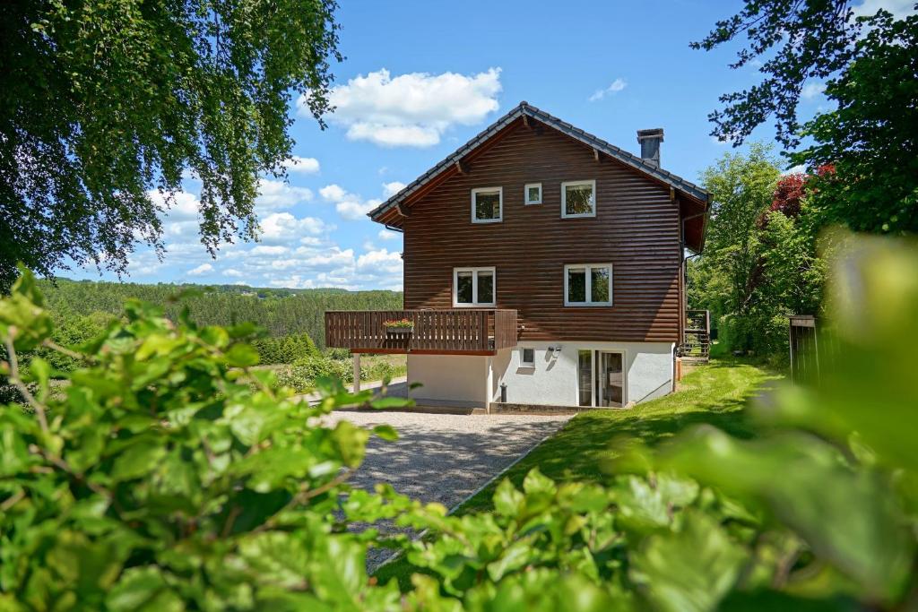 a large wooden house with a balcony on the side at Le Milan Royal 26 pers, Malmedy, Balnéo, vue, calme in Malmedy