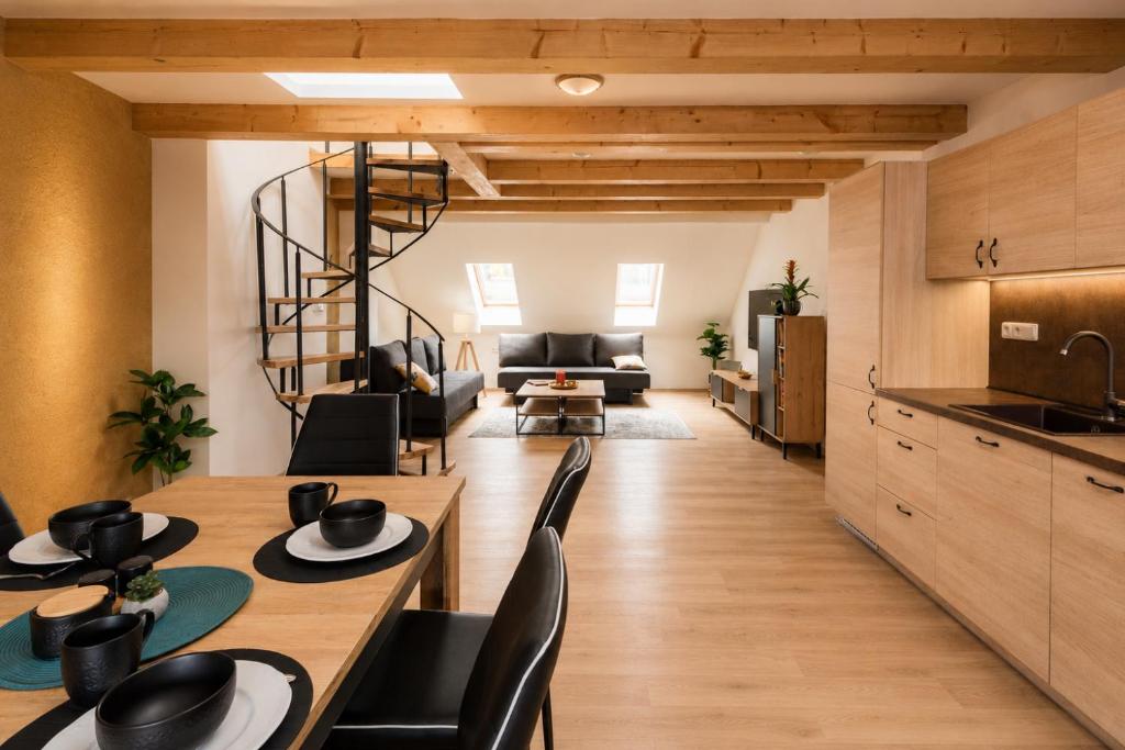 a kitchen and living room with a wooden table and chairs at Ayni Apartment Semily in Bohemian Paradise in Semily