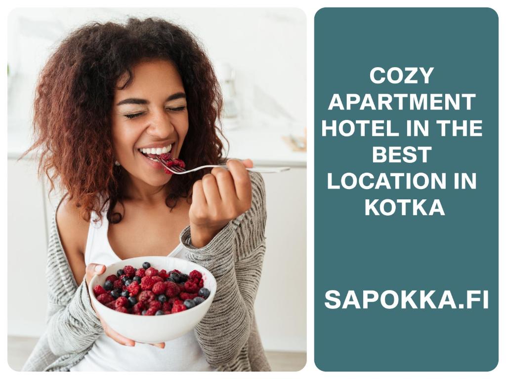 a woman eating a bowl of berries with the words cozy apartment hotel in the best at Reipas Ekonom Accommodation in Kotka