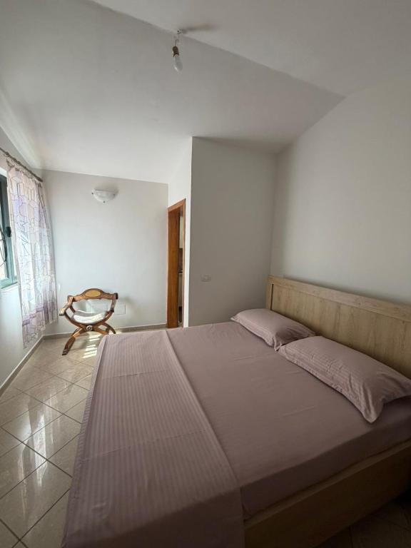 a bedroom with a large bed and a chair at Sun & Sea Shengjin in Lezhë