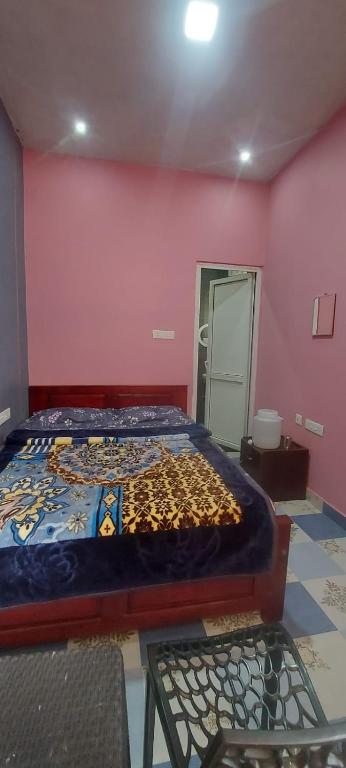 a bedroom with a bed in a pink wall at Steep Valley Resort in Kotagiri