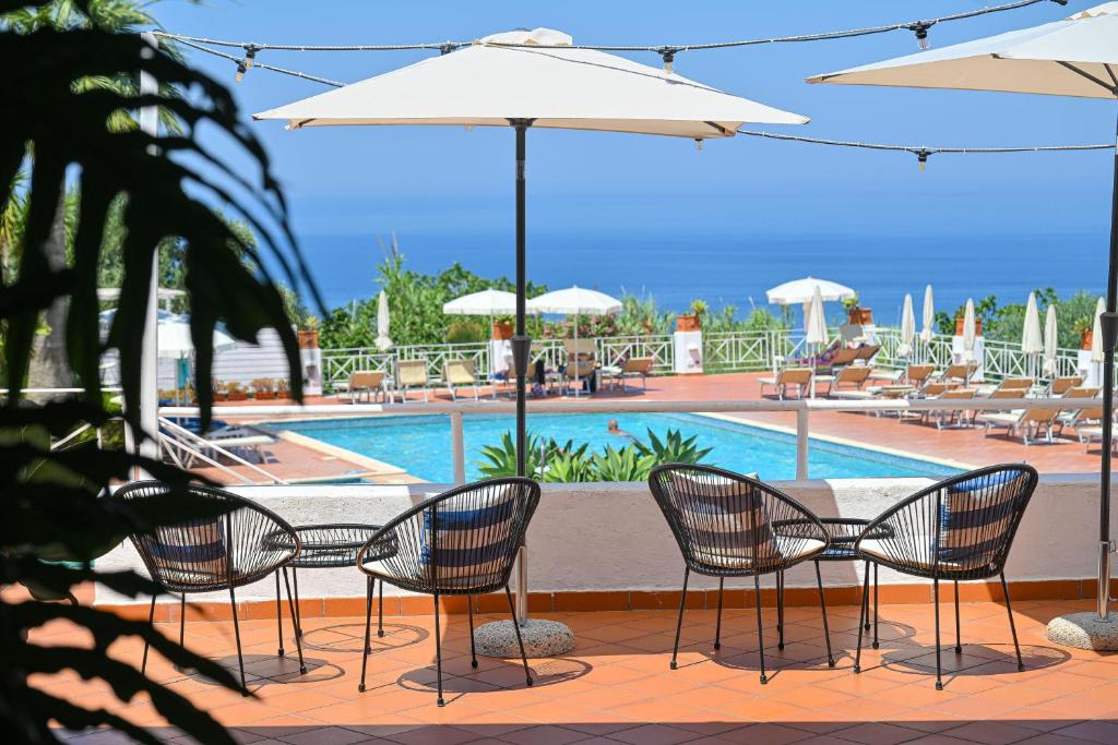 a table and chairs with umbrellas next to a pool at Paradiso Terme Resort & SPA con 5 piscine termali in Forio d'Ischia