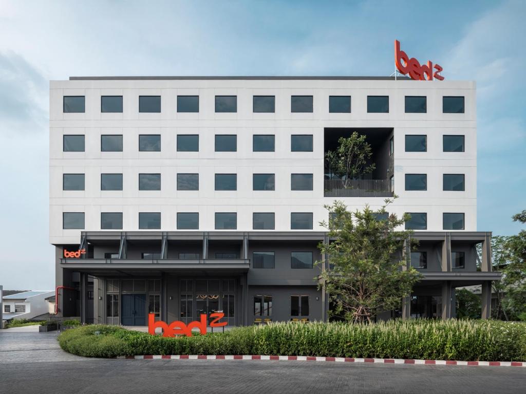 a white building with a dog on top of it at Bedz Hotel Ban Bueng in Ban Bung
