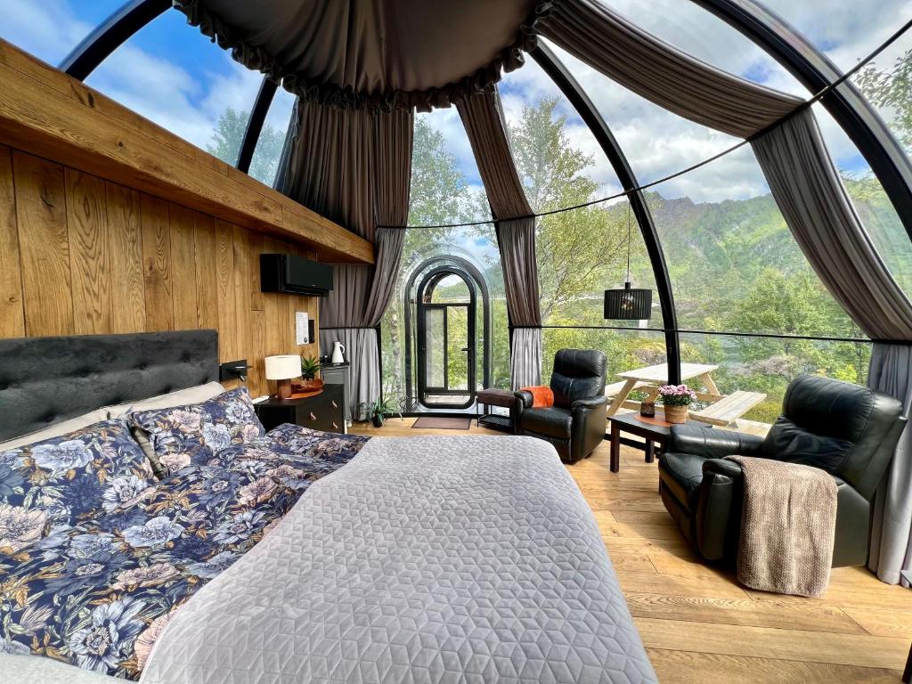 a bedroom with a bed and a large window at Lofoten Aurora Dome in Hanøya