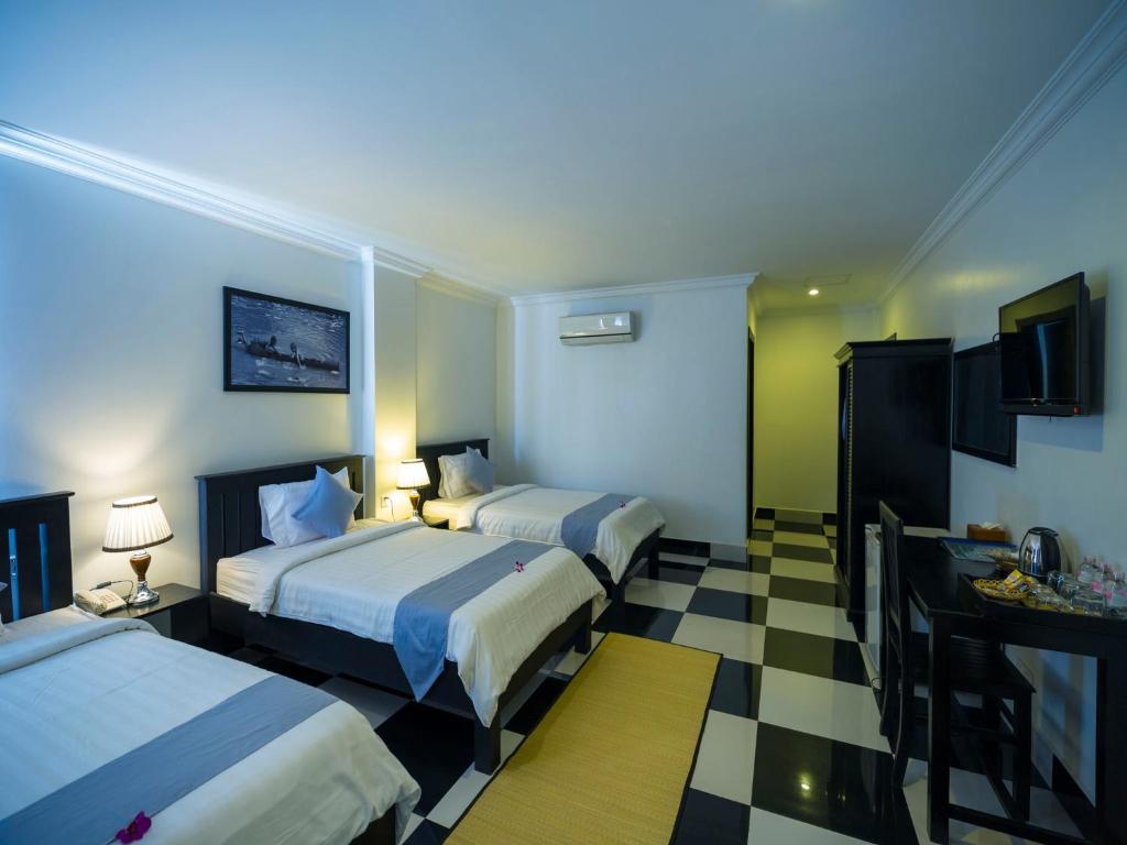 Postel nebo postele na pokoji v ubytování Rithy Rine Angkor Residence