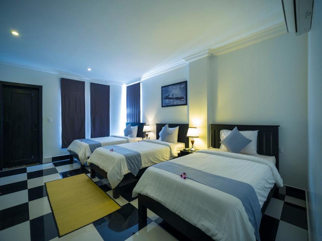 Postel nebo postele na pokoji v ubytování Rithy Rine Angkor Residence