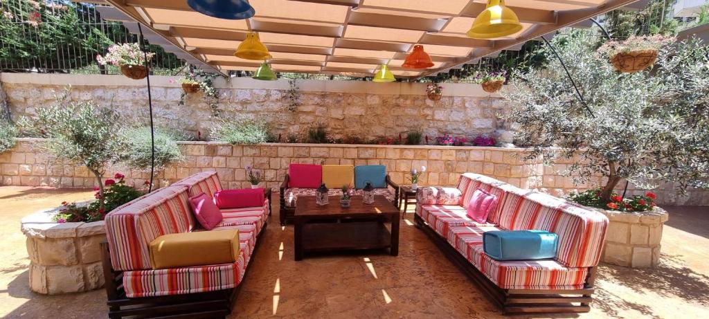 a patio with two couches and a table and chairs at Maison des Couleurs in Aley