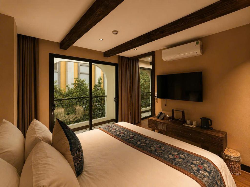 a bedroom with a large bed and a television at The Mysteri Sapa in Sapa