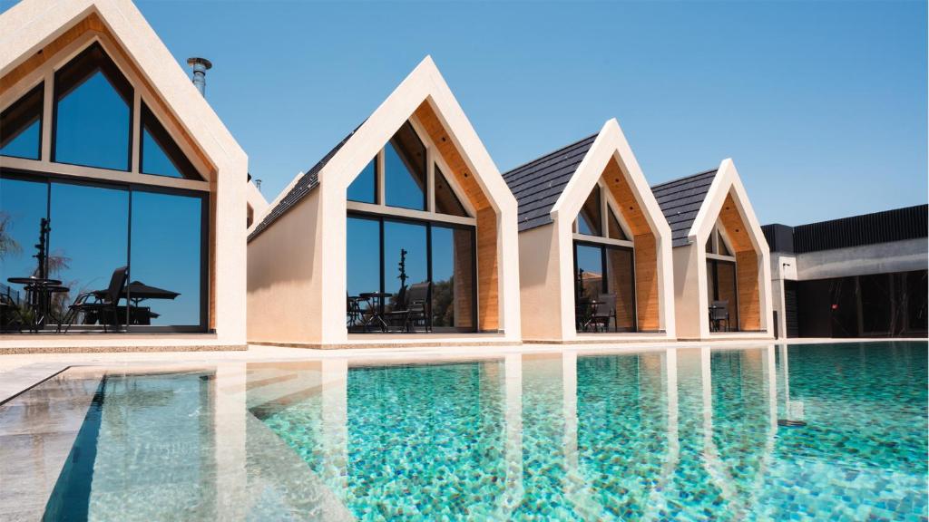 a villa with a swimming pool and windows at NOE Suites in Ayios Theodhoros