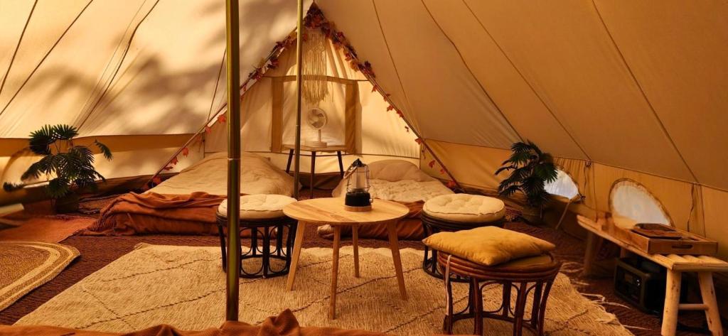 a room with a tent with a bed and a table at Nid et Toiles in Bernadets-Debat