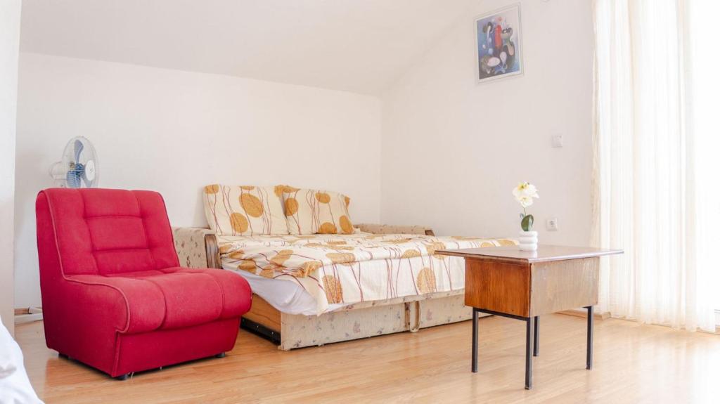 a living room with a red chair and a couch at Atina Apartments in Peštani