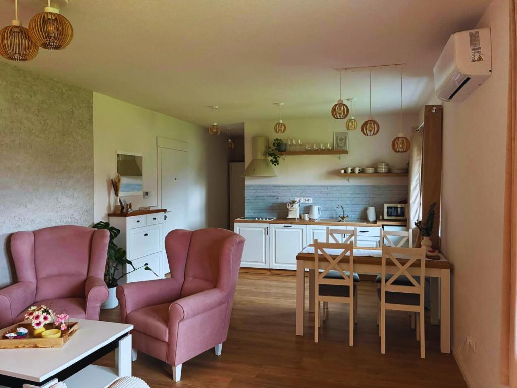 a living room with two chairs and a table and a kitchen at Apartmán Zulu in Liptovský Mikuláš