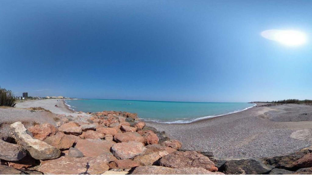 a pile of rocks on a beach next to the water at Moncofa Beaches Apartment in Moncófar