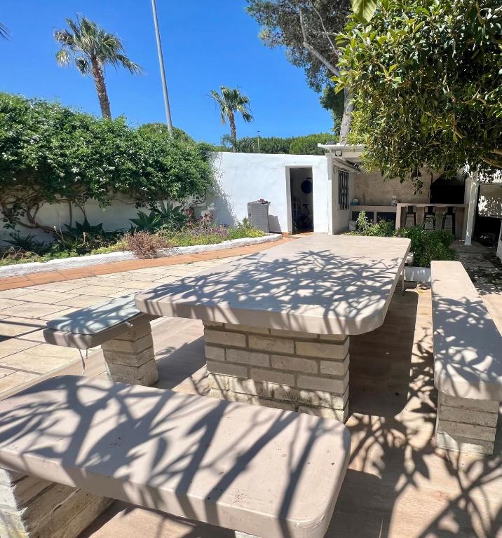 a picnic table with its shadows on the ground at Casa Playa La Barrosa in Novo Sancti Petri
