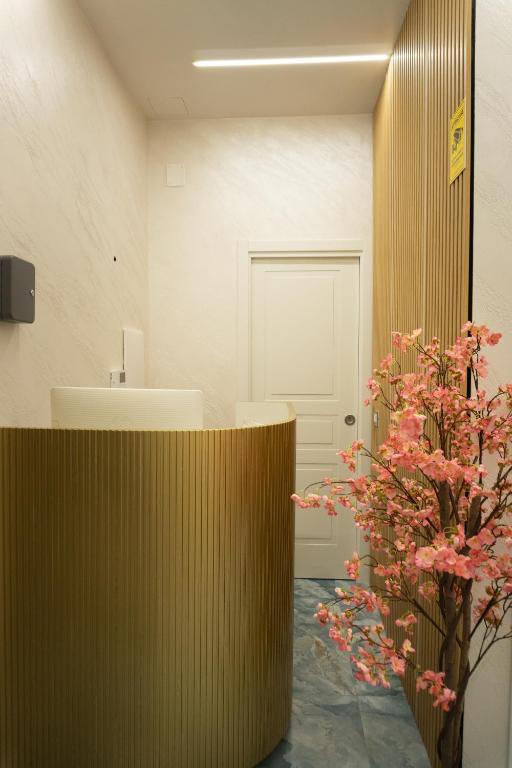 a bathroom with a counter and a plant with pink flowers at Na Suite QuartieriSpagnoli in Naples