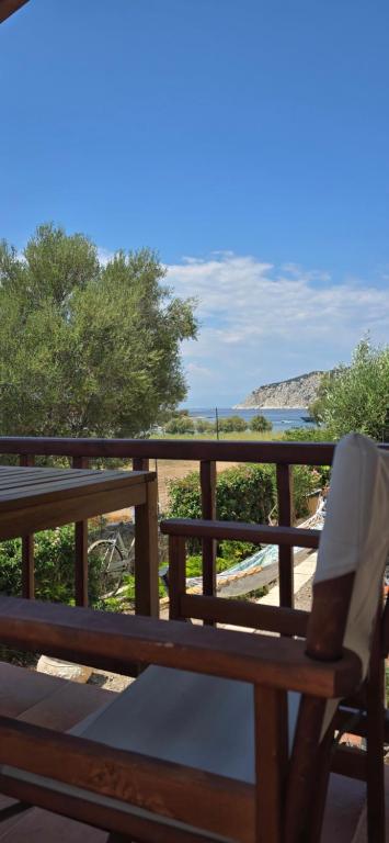 a wooden bench sitting on a balcony overlooking the ocean at Perivleptos Ι in Perdika