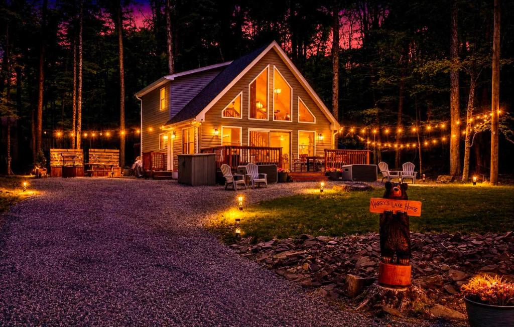 a cabin in the woods at night with lights at Brand New Chalet - Seclusion Arcadez Fire Pit in Locust Lakes Village