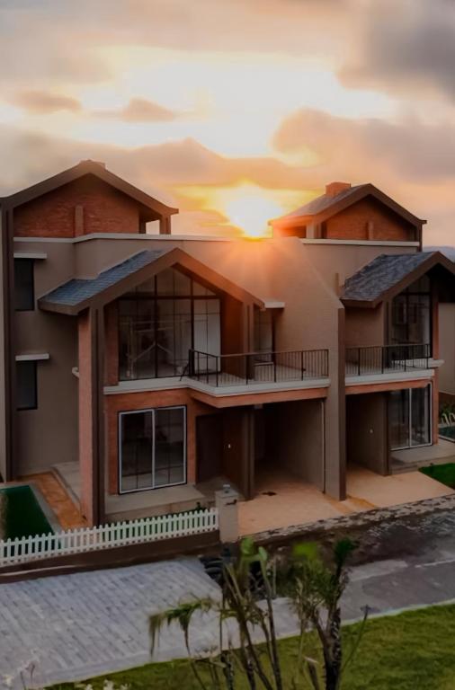 a house with the sunset in the background at Woods Luxury Villas in Lonavala