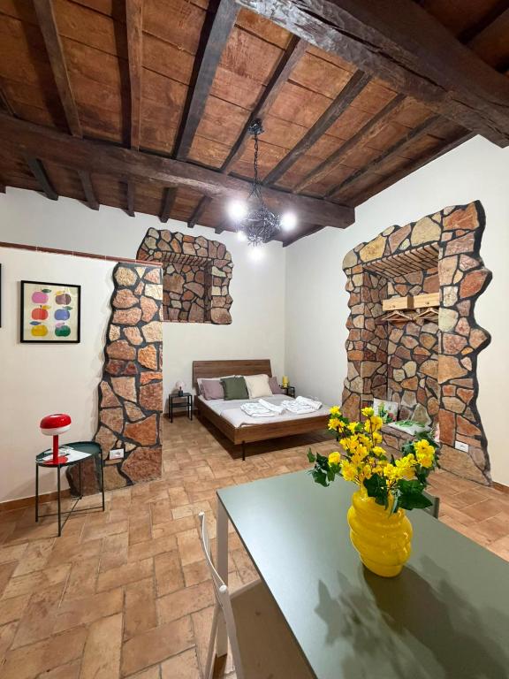 a living room with a stone wall and a bed at DiVa in Castelnuovo di Farfa