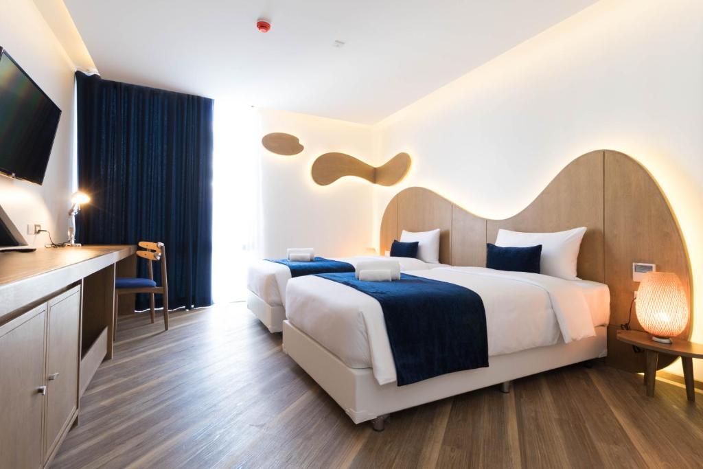 バンコクにあるKlub Hotel Bangkokのベッドとテレビが備わるホテルルームです。