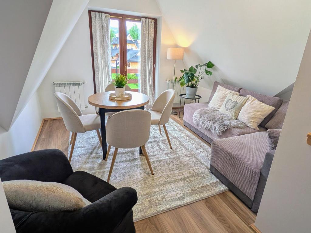 a living room with a table and a couch at Willa Murań in Murzasichle