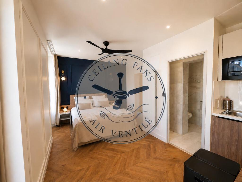 a large wall clock in a room with a bed at The Originals Residence, Les Sources Callou, Vichy in Vichy