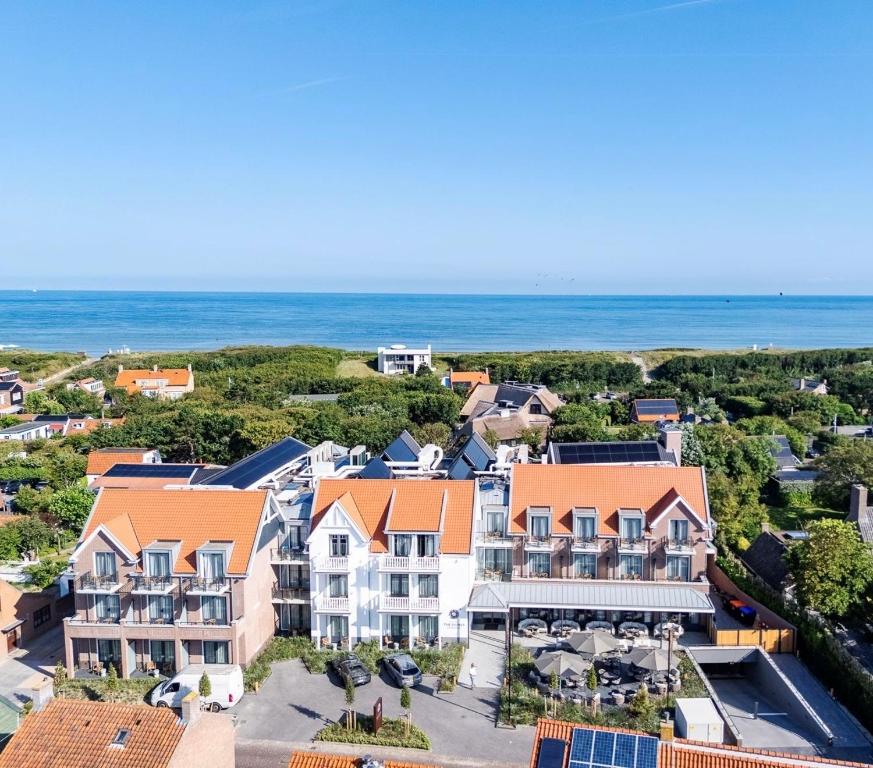an aerial view of a house with the ocean in the background at Hotel The Dunes in Domburg