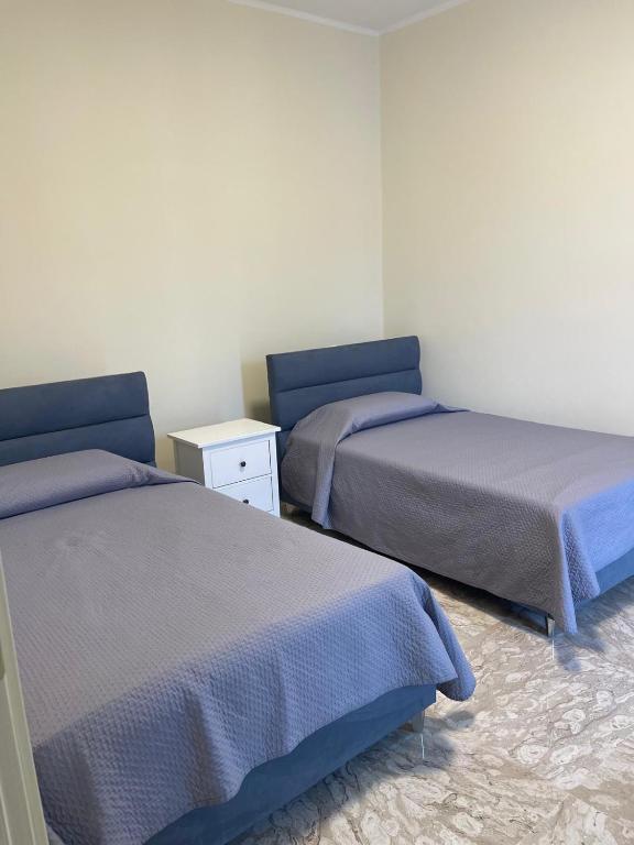 a room with two beds and a nightstand between them at B&B Dosti in Scafa