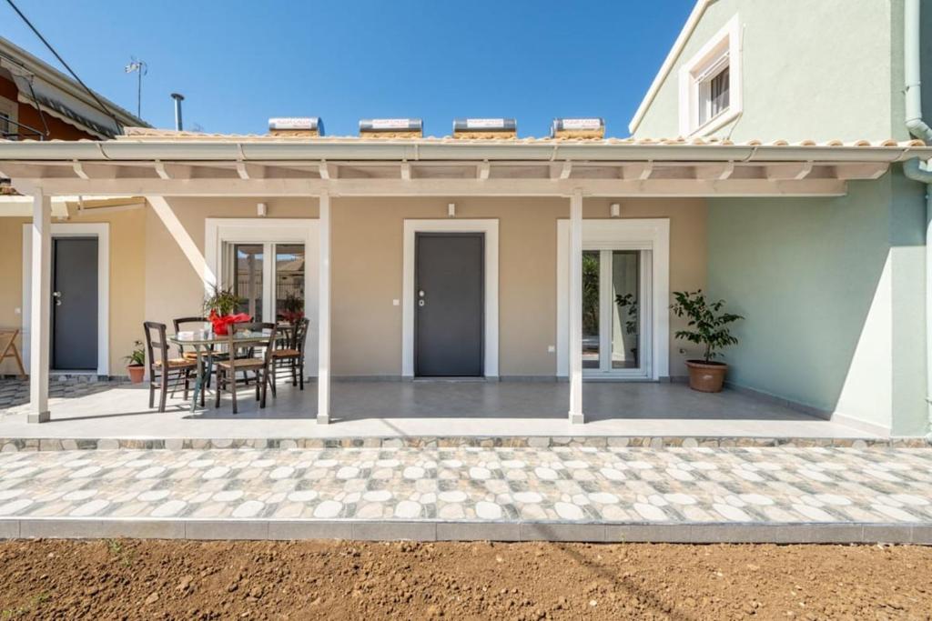 a house with a patio with a table and chairs at Jimmy's by the beach ipsos in Ipsos
