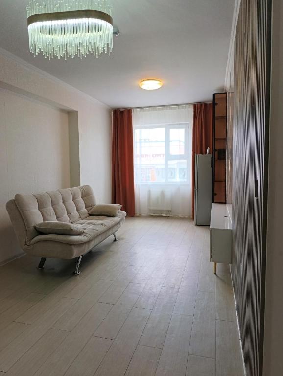 a living room with a couch and a chandelier at Darkhan Apartment in Darhan