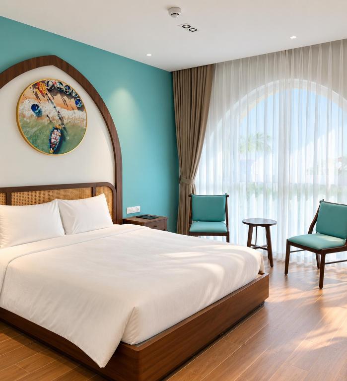 a bedroom with a large bed and two chairs at Sonasea Van Don Letavia Hotel in Thâm Câu