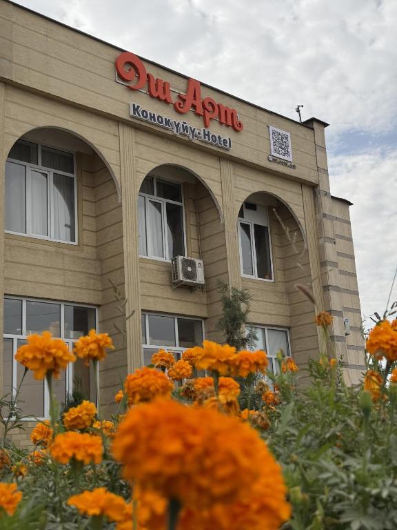 a building with orange flowers in front of it at Osh Art Hotel in Osh