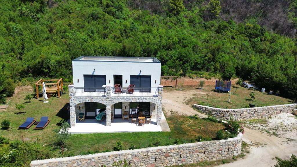 a small white house with a stone wall at Maginja in Petrovac na Moru