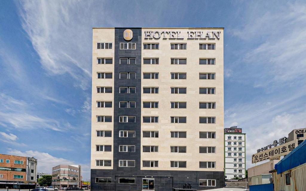 a tall white building with a clock on it at Ehan Hotel in Mokpo