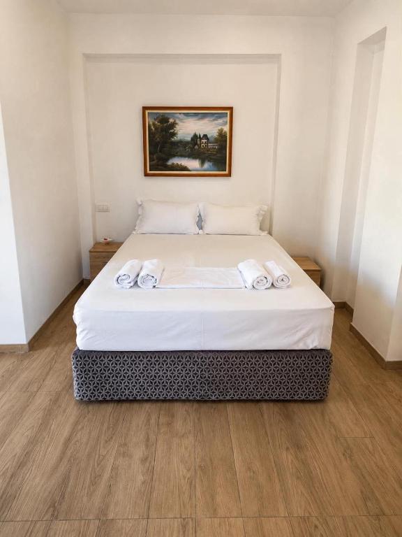 a bedroom with a bed with two towels on it at Prestige Rooms Andros in Gavrio