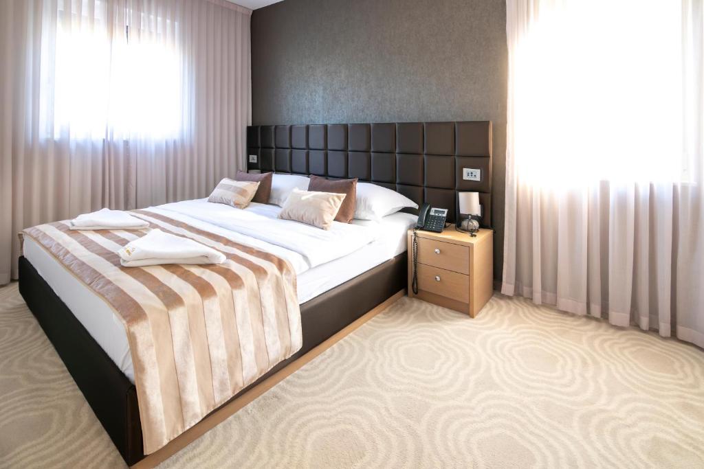 a bedroom with a large bed and a window at Royal Airport Hotel in Velika Gorica