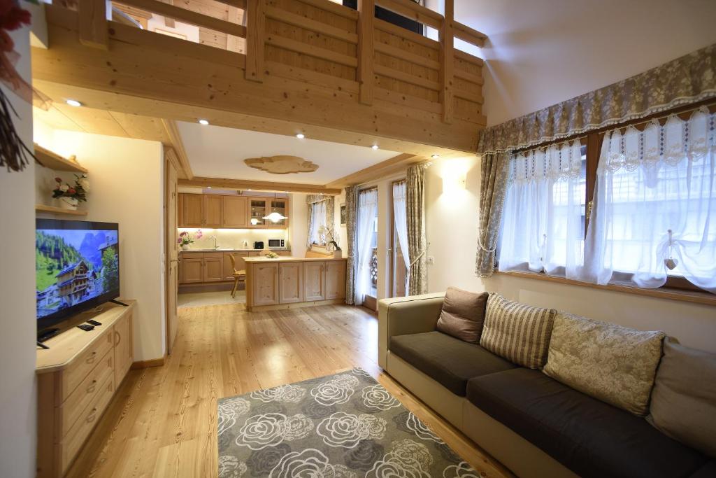 a living room with a couch and a flat screen tv at Romantic Chalet Dolomiti in Val di Zoldo
