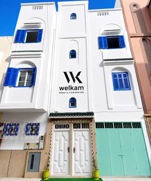 a white building with the wxk sign on it at WELKAM Home & Coworking in Essaouira